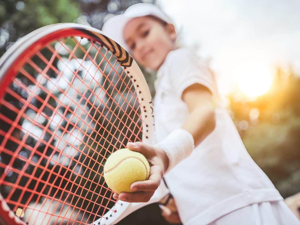 Photo d'une petite fille entrain de jouer au tennis.