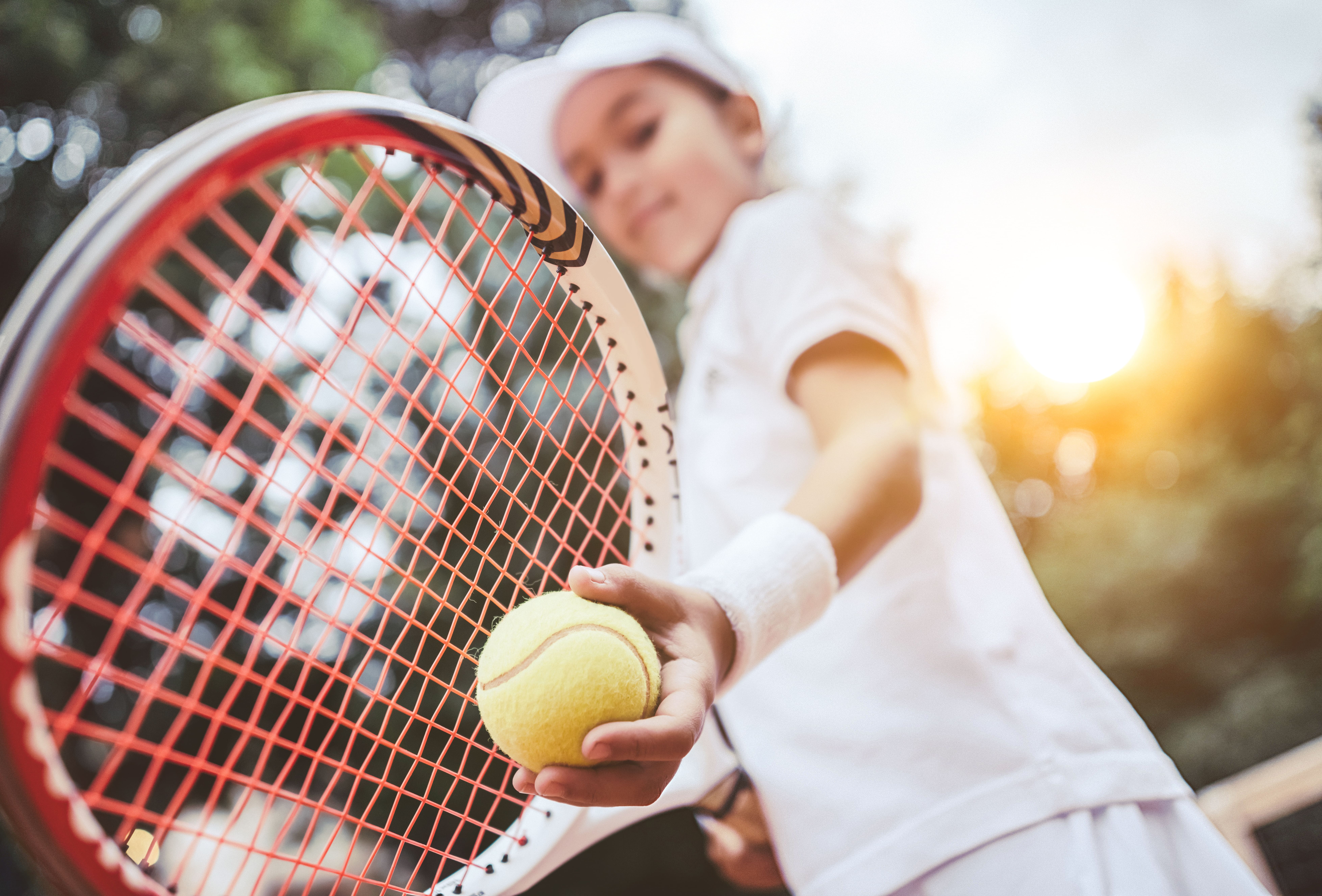 Photo d'une petite fille entrain de jouer au tennis.